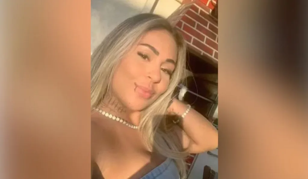 mulher loira com tatuagens no pescoço em frente a uma churrasqueira