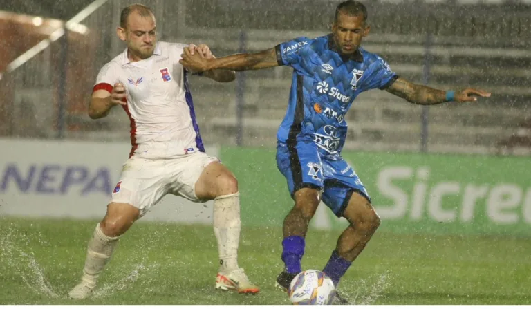 Jogadores de Paraná x Azuriz em disputa de bola, sob forte chuva