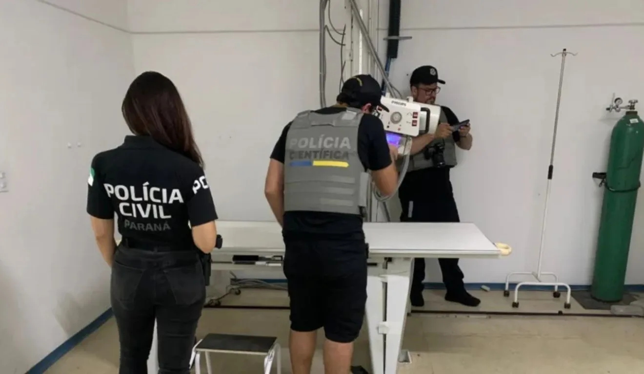 polícia em uma clínica ao lado de um equipamento de raio-x