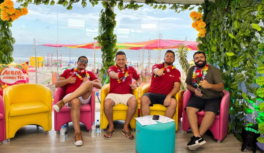 quatro homens sentados em cadeiras e de fundo a praia na Arena Mundo Ric