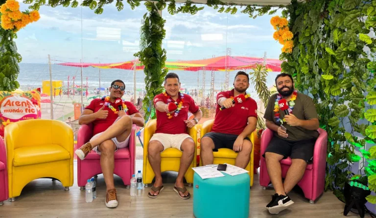 quatro homens sentados em cadeiras e de fundo a praia na Arena Mundo Ric