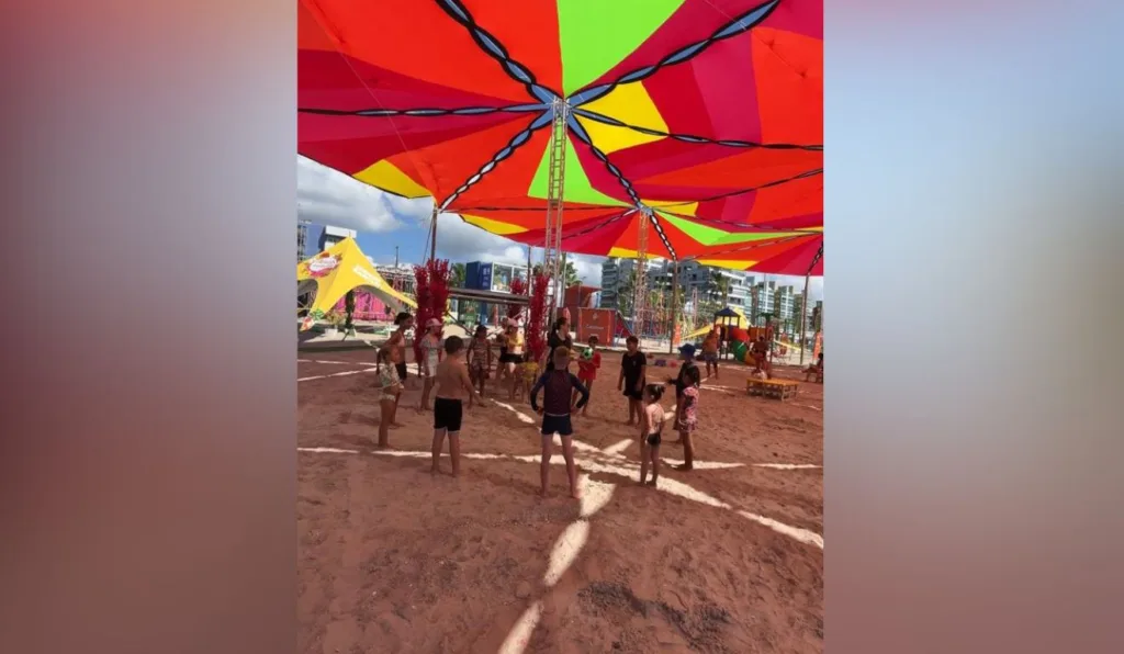 crianças em pé em formato de roda na areia da praia