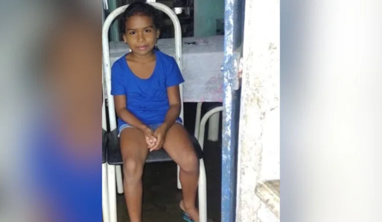 criança de camiseta azul sentada em uma cadeira