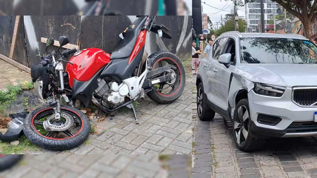 Moto vermelha no chão com a roda da frente quebrada e carro cinza com a parte frontal direita batida