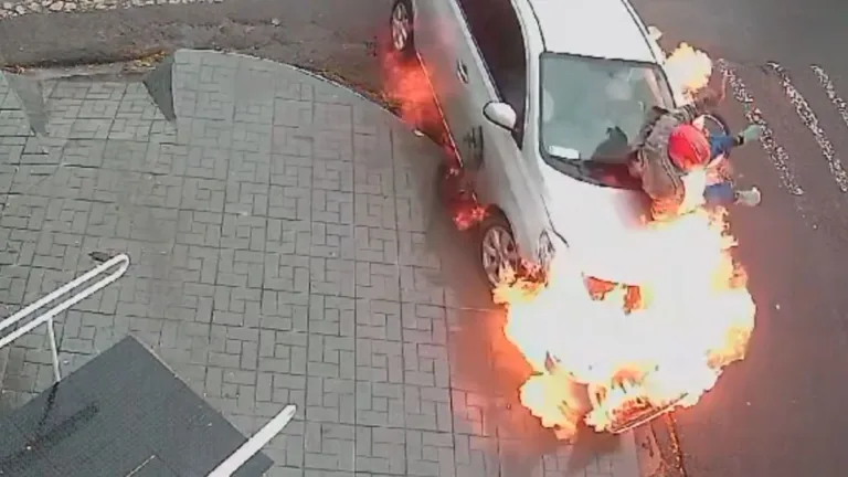 Moto colide em carro, pega fogo e motociclista para em cima de veículo; vídeo
