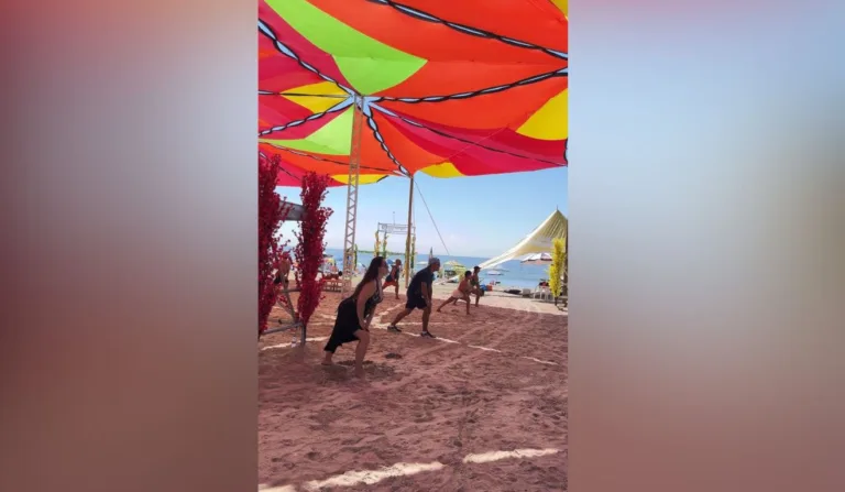 pessoas se alongando na areia da praia