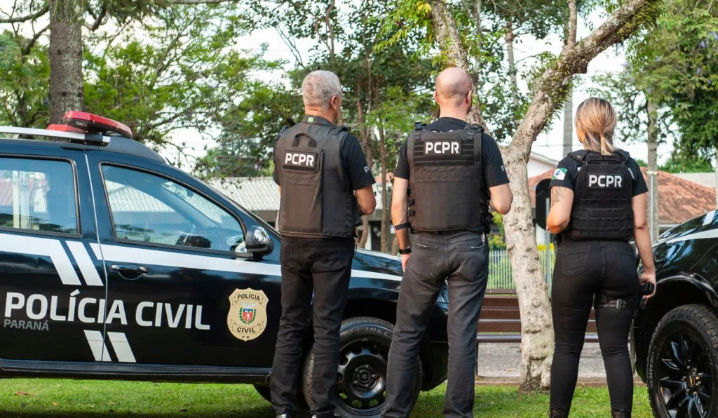 policiais civis ao lado de viatura