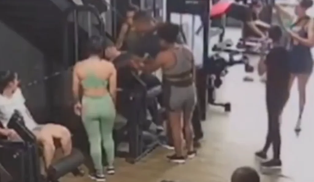 Momento em que a mulher passa mal e é socorrida por outras pessoas presentes na academia.