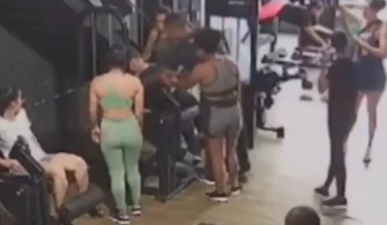 Momento em que a mulher passa mal e é socorrida por outras pessoas presentes na academia.