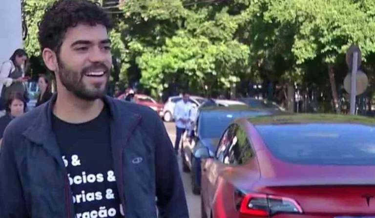 A imagem mostra o engenheiro e um Tesla.