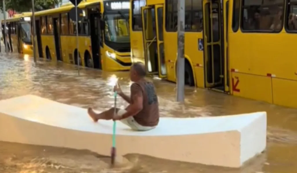 Homem enfrenta alagamento com canoa de isopor e remo de vassoura
