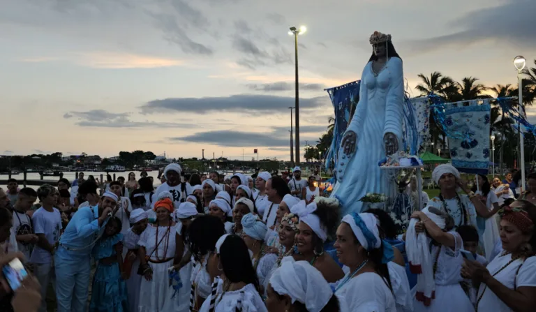 Diversas pessoas ao redor de uma imagem de Iemanjá.