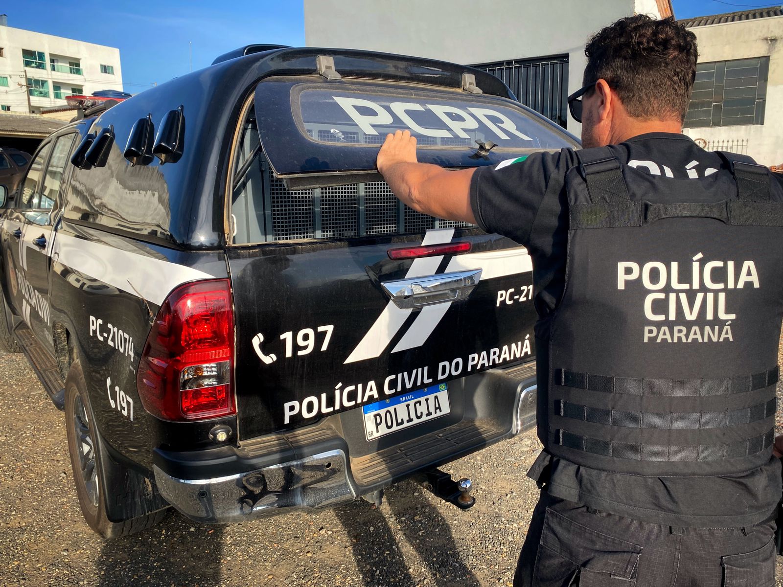 Policial civil fechando viatura da corporação