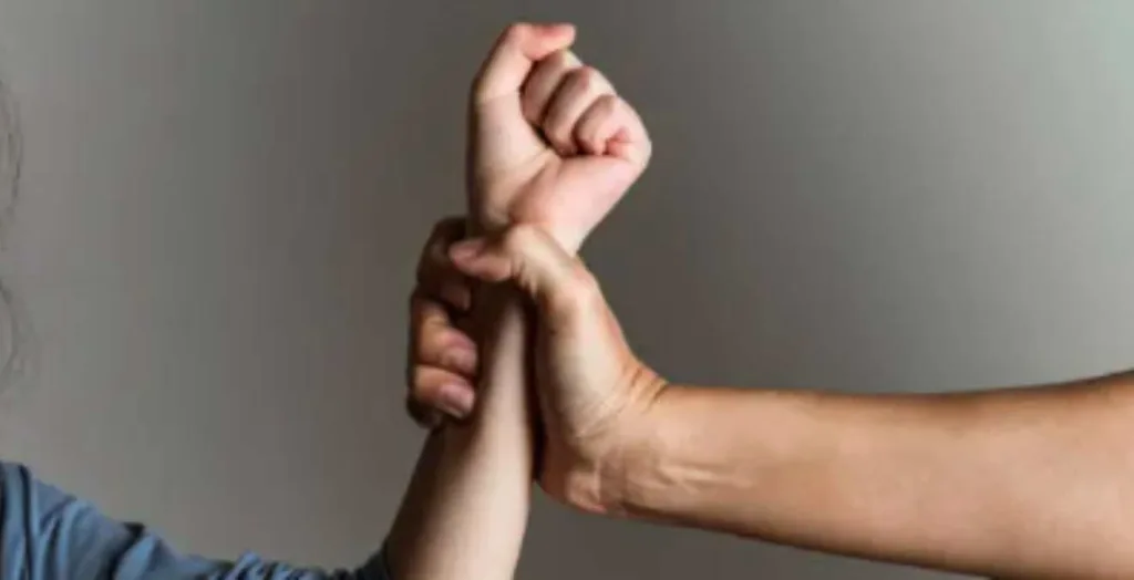 Criança sendo segurada pelo braço, simbolizando o controle e a situação de vulnerabilidade após ser agredida pela mãe.