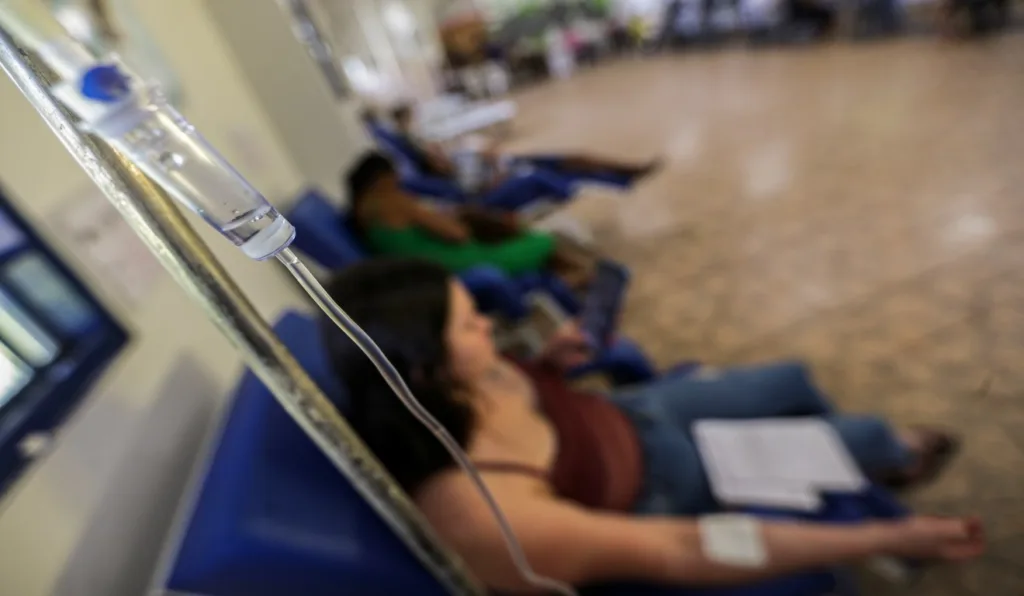 Pacientes com suspeita de dengue em postinho, tomando medicação.
