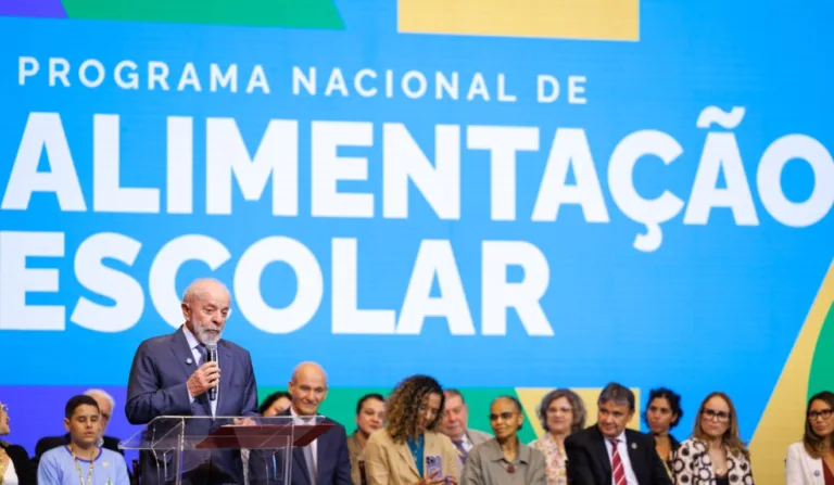 A imagem mostra o presidente Lula discursando no Programa Nacional de Alimentação Escolar.