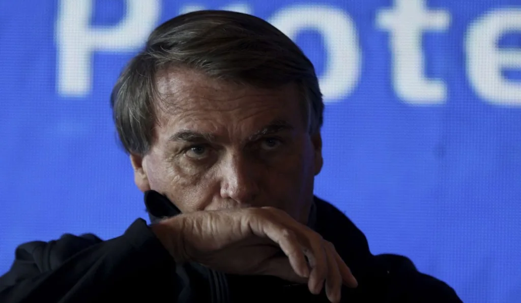 Bolsonaro com a mão na boca.