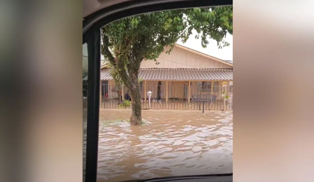 foto de uma rua alaga e uma casa em meio a água
