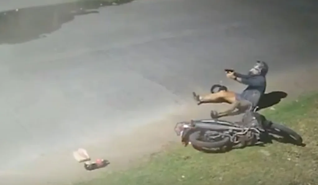 Policial atirando com moto caída