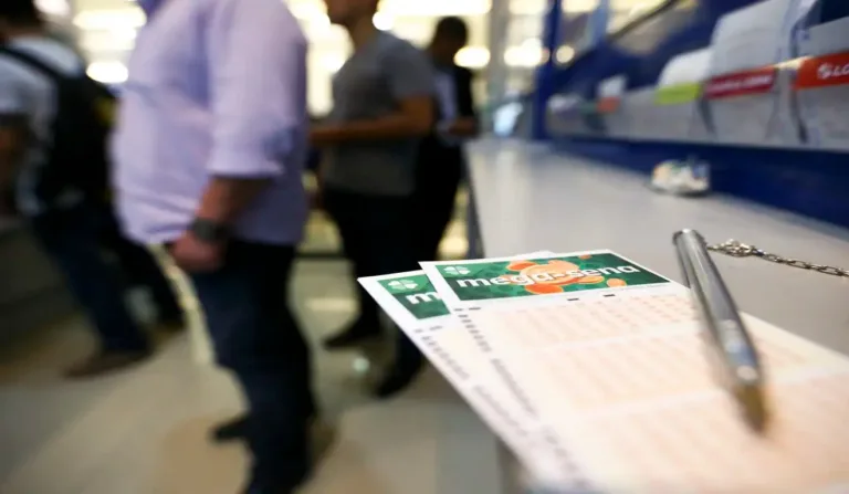 Mega-Sena em cima do balcão em lotérica, com pessoas ao fundo.
