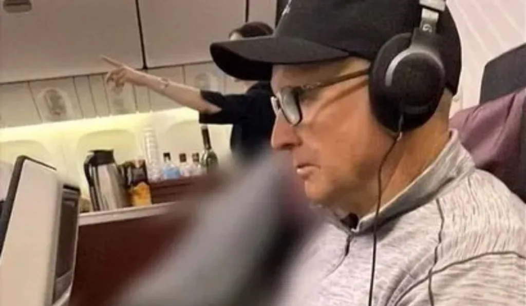 homem sentado ao lado de cadáver no avião