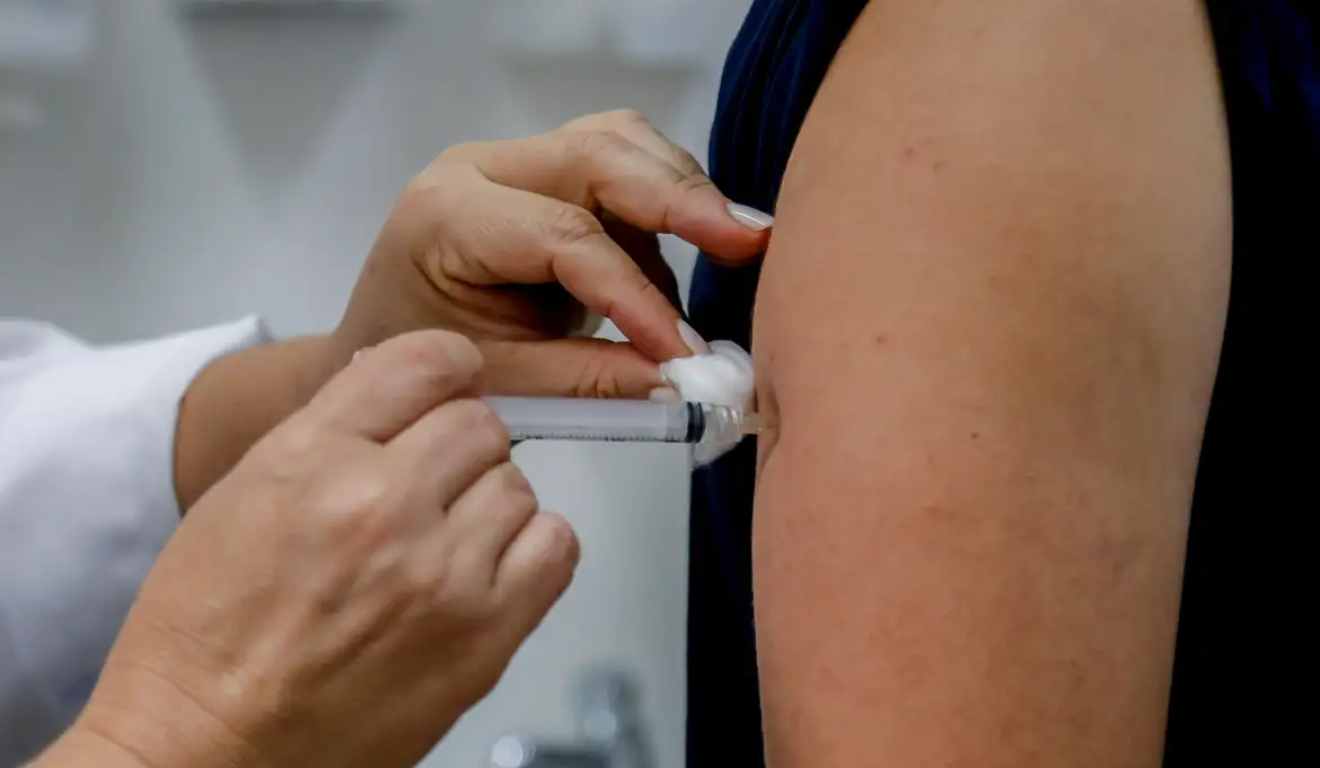 Vacina sendo aplicada no braço de um paciente.