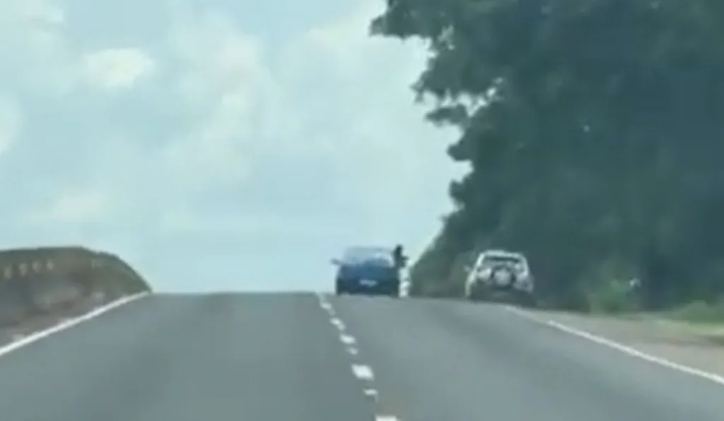 foto de um homem para fora da janela do carro durante um assalto 