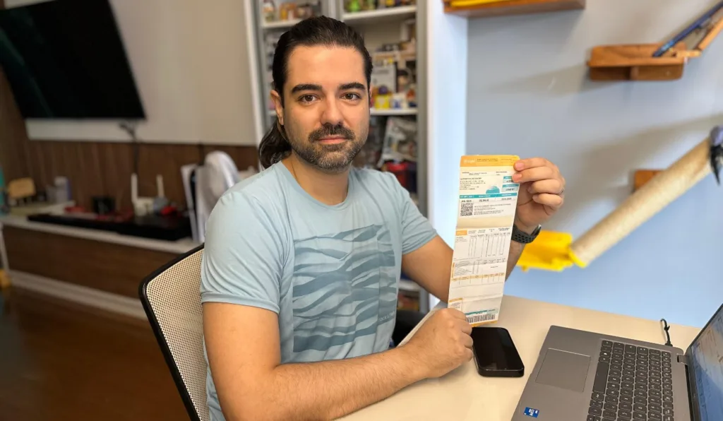 Heleno Martinez de Almeida exibindo a conta de luz com o desconto do bônus Itaipu