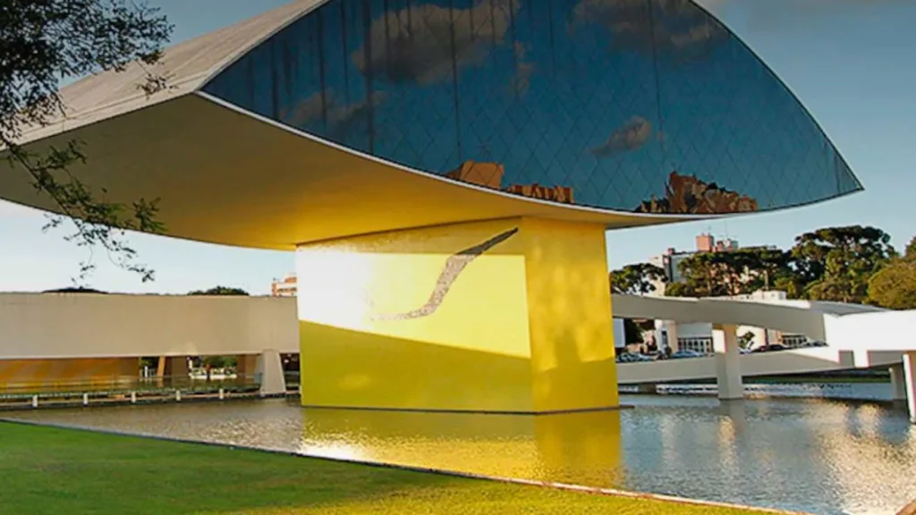 Imagem do Museu do Olho, em Curitiba, com sua estrutura arquitetônica única e moderna, destacando o design do edifício que remete ao formato de um olho.