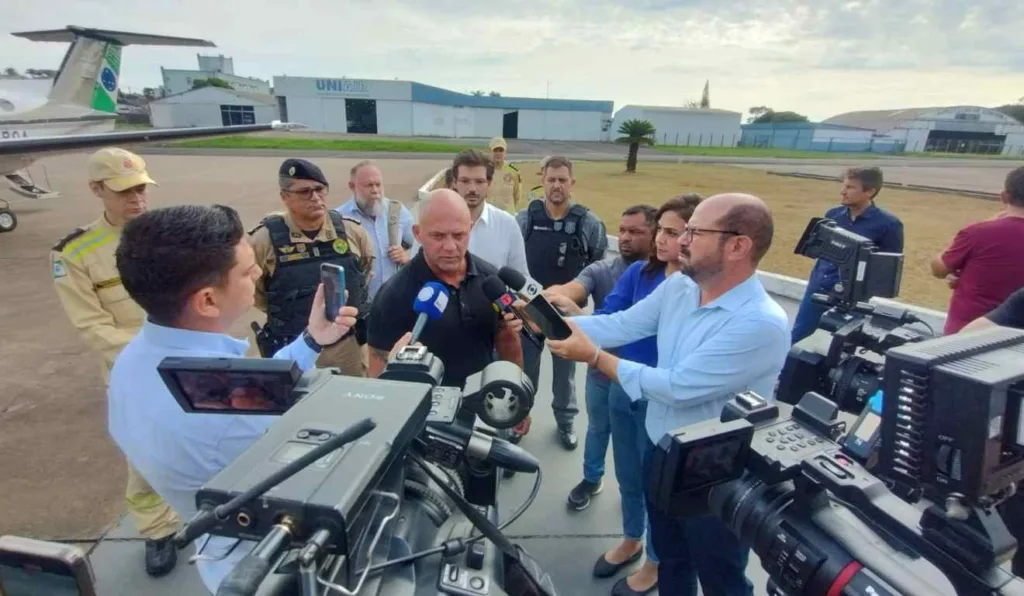 O secretário de Segurança Pública do Paraná, Hudson Leôncio Teixeira, dando entrevista à imprensa em aeroporto.