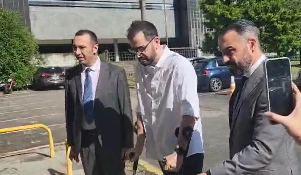 Jorge Guaranho (camisa branca) chega para júri acompanhado de advogados