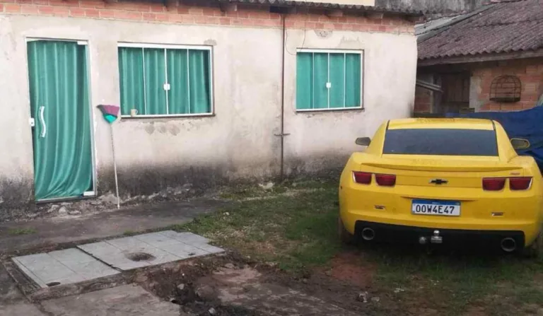 Carro de luxo estacionado em frente a casa.