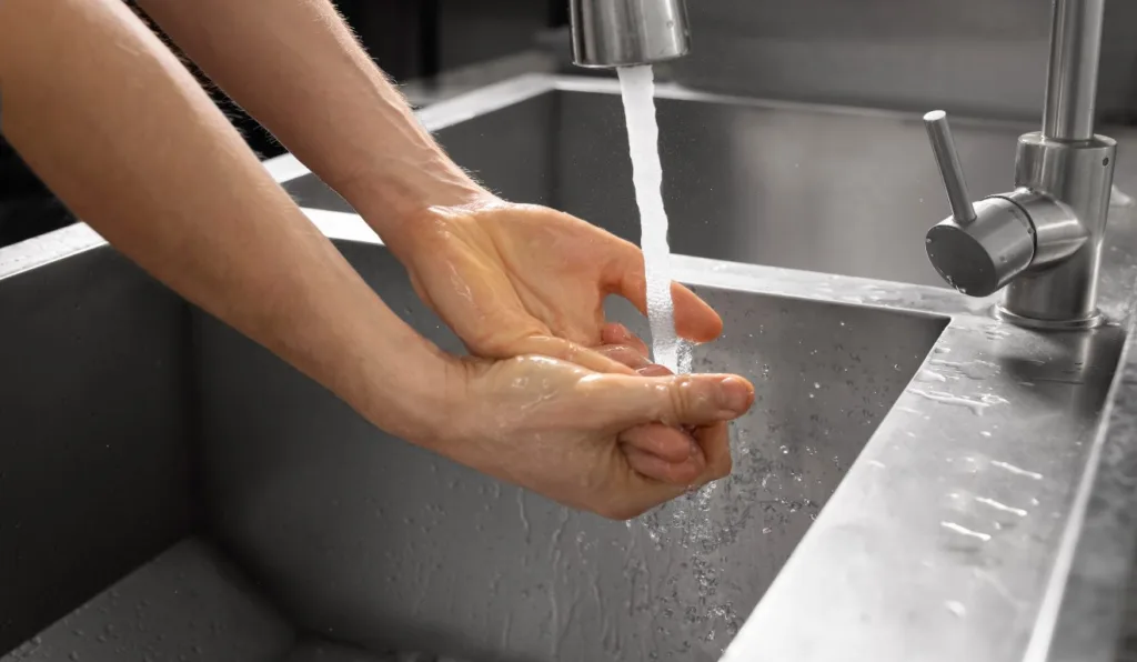 Pessoa lavando as mãos.