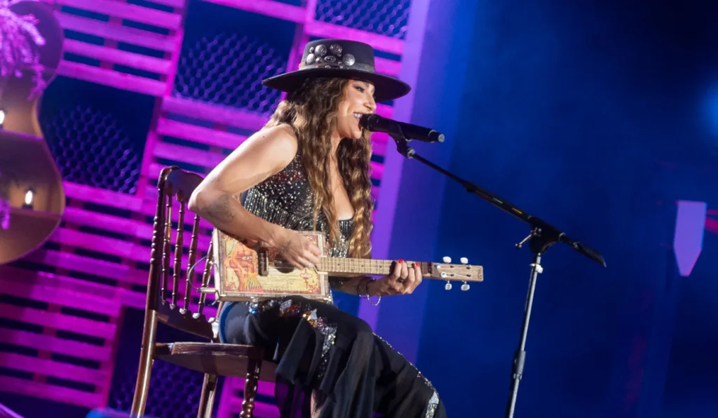 Lauana Prado se apresenta no palco com a guitarra, cheia de energia durante sua turnê "Raiz".