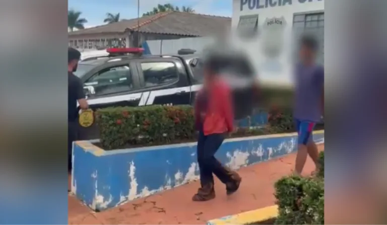 Imagem dos suspeitos na frente da delegacia.