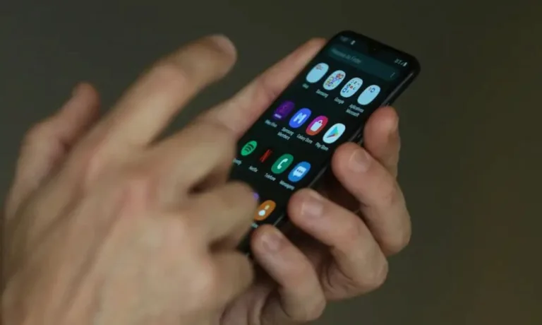 Mão mexendo em celular