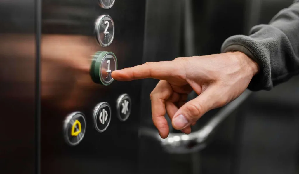 Mão apertando botões de elevador