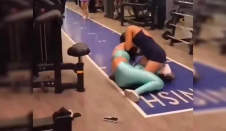 Duas mulheres no chão da academia em luta corporal