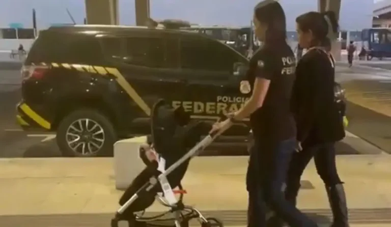 Policiais carregam bebê vítima de tráfico internacional