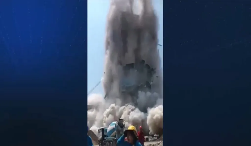 Prédio desabando e pessoas correndo.