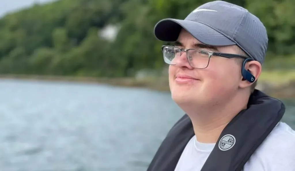 jovem de óculos sorrindo de boné