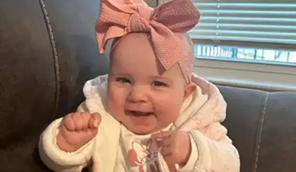 bebê sorrindo com laço na cabeça