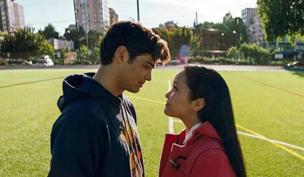 garoto e garota adolescente se encarando em um campo de futebol