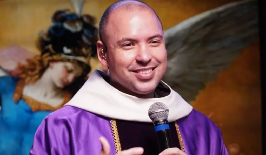 homem segurando um microfone e sorrindo.