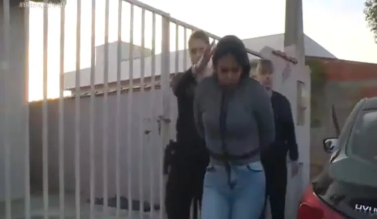 Imagem da suspeita sendo presa.