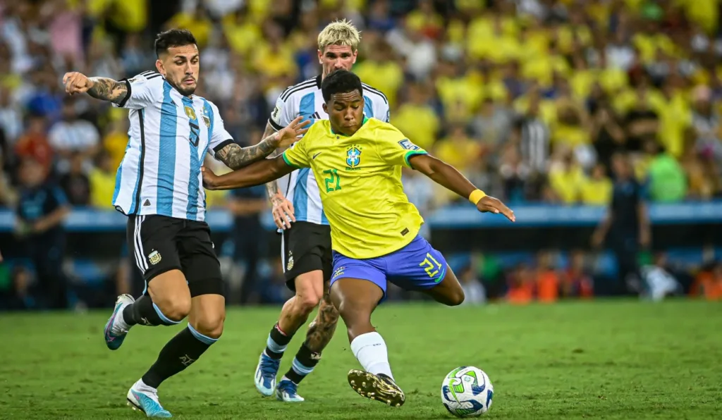 Endrick disputando a bola com De Paul e Paredes em um Brasil X Argentina.