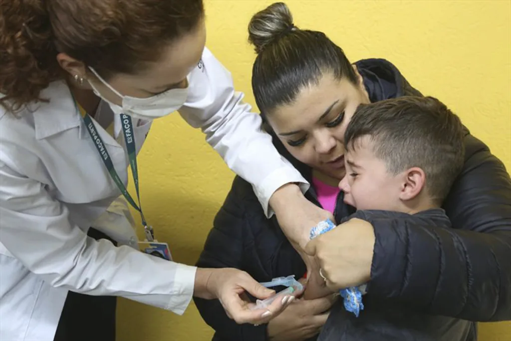 Criança vacinada em escola de Curitiba, durante campanha da vacinação