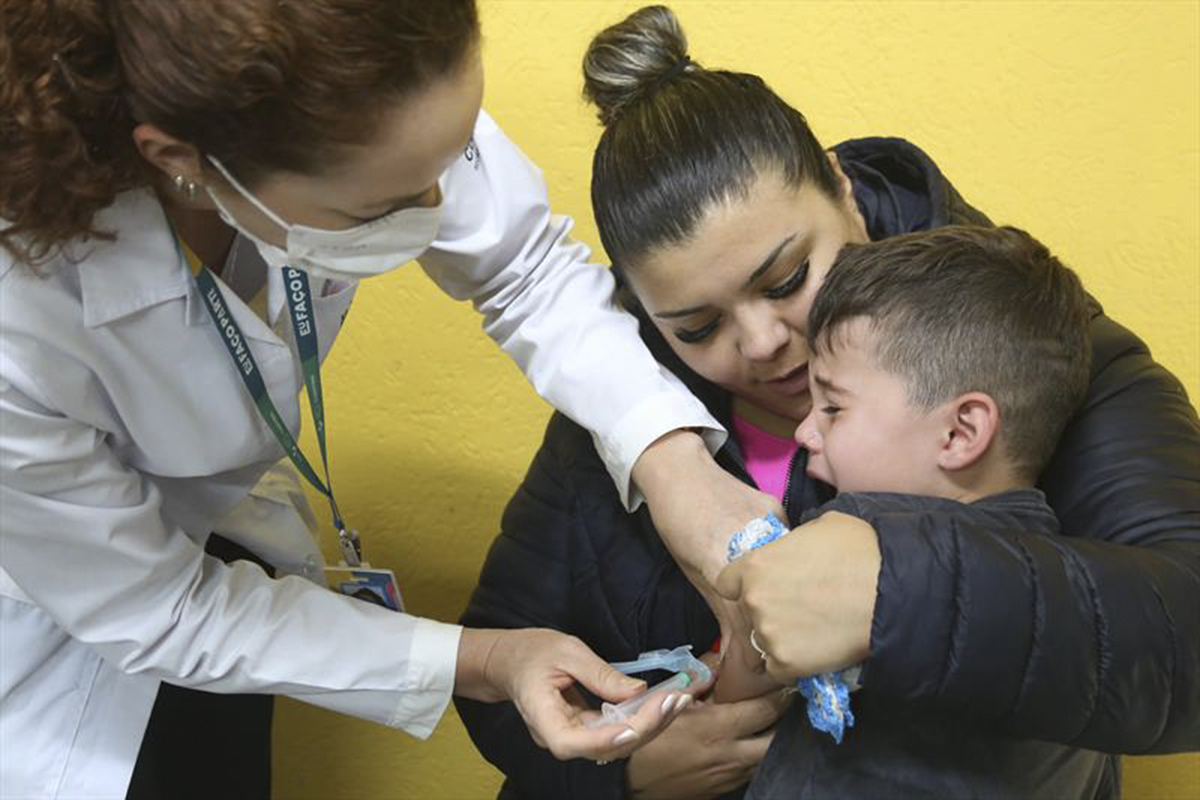 Criança vacinada em escola de Curitiba, durante campanha da vacinação