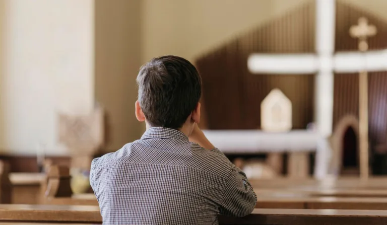 homem orando em uma igreja católica