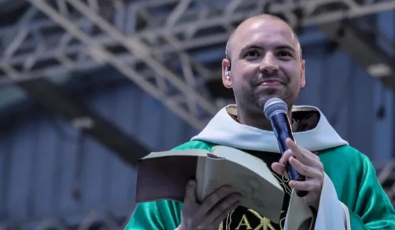 Frei Gilson segurando bíblia e um microfone